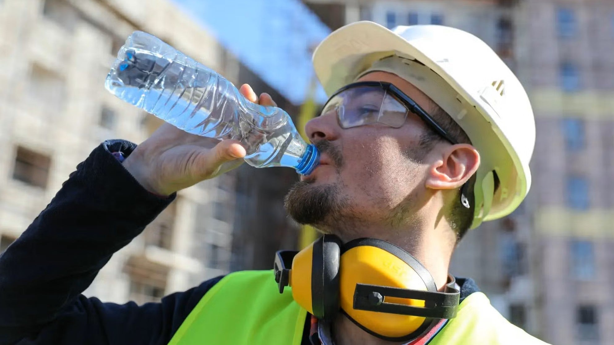 Un travaille de la construction boit de l'eau