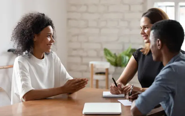 Jeune femme souriante parlant avec des employeurs lors d'une entrevue d'embauche
