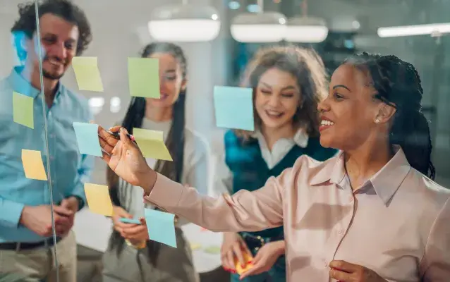 Femme d’affaires écrivant sur des post-it lors d’une séance de brainstorming