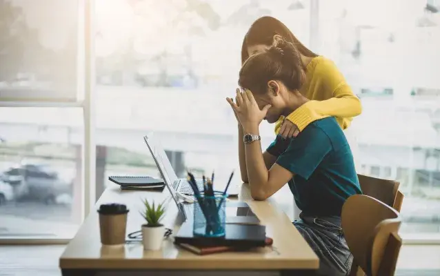 Collègue réconfortant la femme stressée et découragée au bureau.