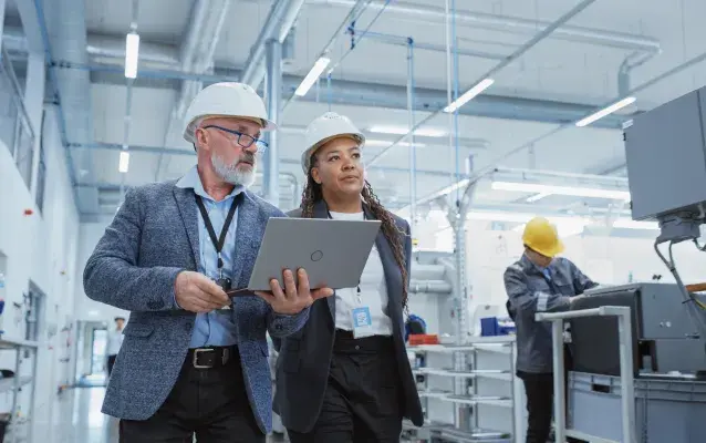 femme et homme portant un casque de sécurité dans une usine