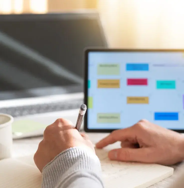 Personne planifiant des rendez-vous et des dates calendaires, organisant un calendrier hebdomadaire ou mensuel pour les réunions avec les clients, les appels et les événements au bureau à l’aide d’une tablette numérique.