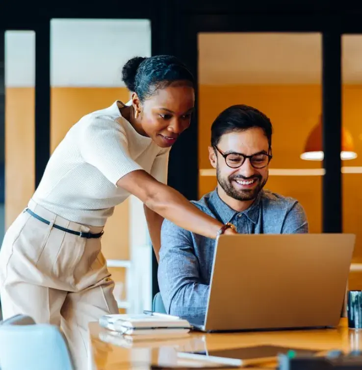 Professionnels discutant d’un projet tout en utilisant un ordinateur portable dans un bureau