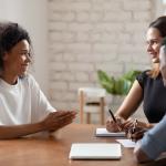 Jeune femme souriante parlant avec des employeurs lors d'une entrevue d'embauche