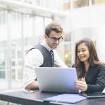 Homme et femme d'affaires en discussion devant ordinateur au bureau