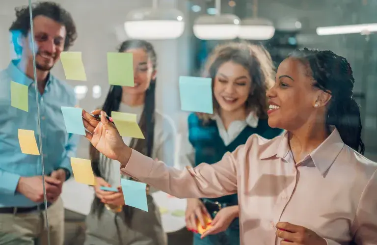 Femme d’affaires écrivant sur des post-it lors d’une séance de brainstorming