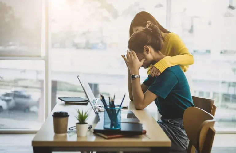 Collègue réconfortant la femme stressée et découragée au bureau.