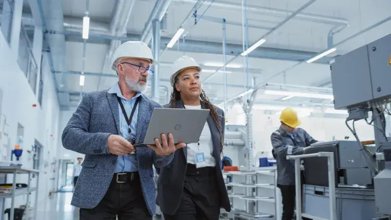 femme et homme portant un casque de sécurité dans une usine