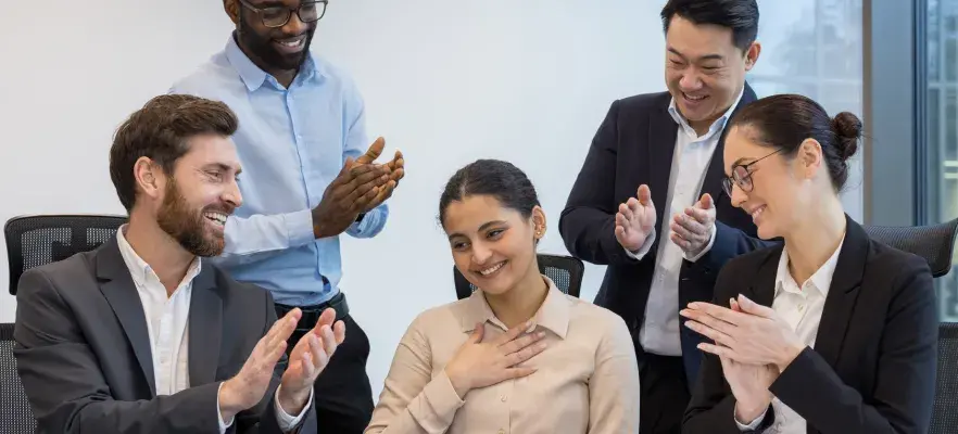 Les collègues se réjouissent et félicitent leur partenaire, un groupe diversifié de gens d’affaires sur le lieu de travail.