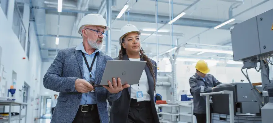femme et homme portant un casque de sécurité dans une usine
